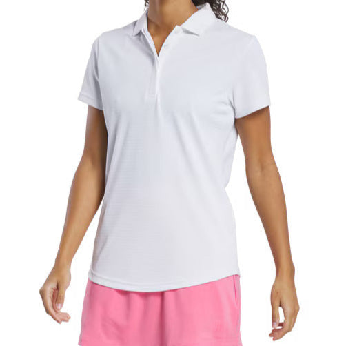 Woman wearing a white polo shirt and pink skirt on a white background