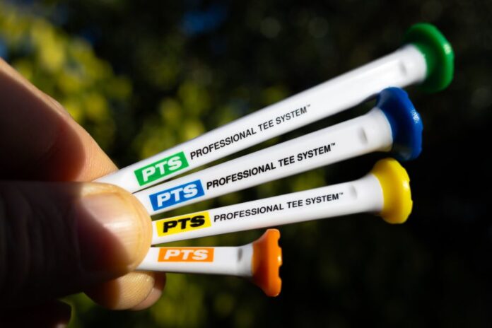 Four PTS Professional Tee System markers held by a hand with a blurred background