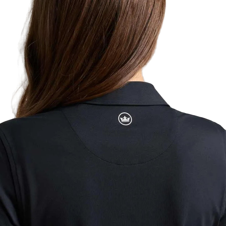 Back view of a woman with long brown hair wearing a dark navy collared polo shirt with a small white crown logo on the upper back, against a light gray background.