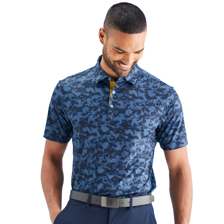 Man wearing a blue camouflage polo shirt against a light blue background