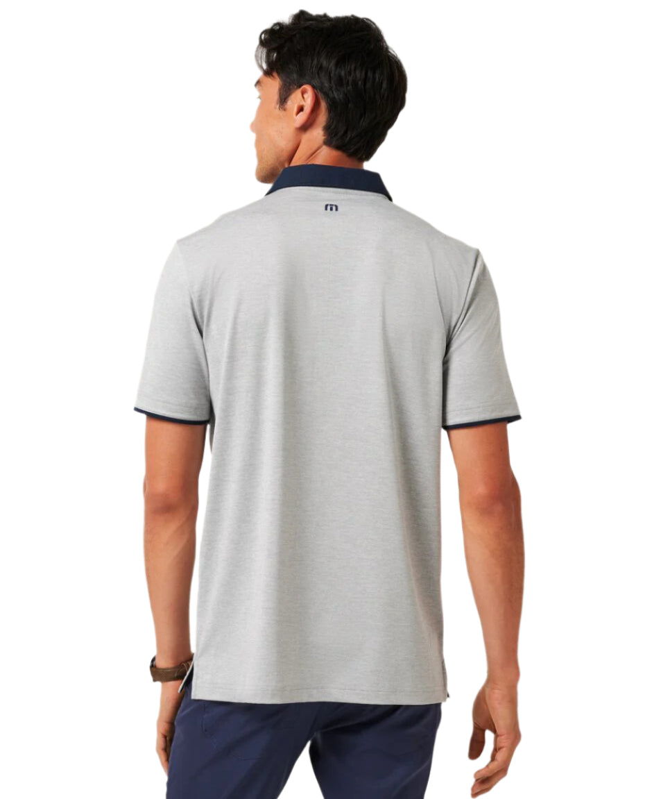 Man wearing a gray polo shirt with a brand logo on the back, standing against a white background