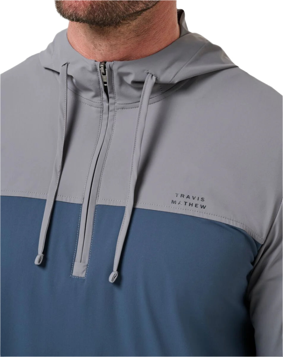Gray and blue jacket with 'Travis Mathew' branding on a neutral background