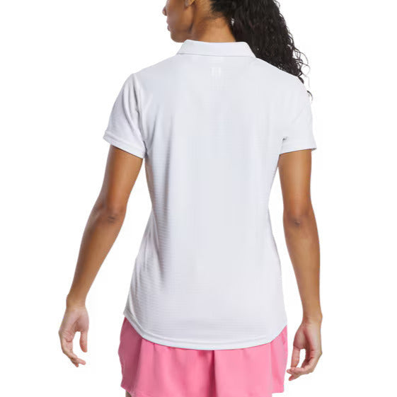 Woman wearing a white polo shirt and pink skirt on a white background