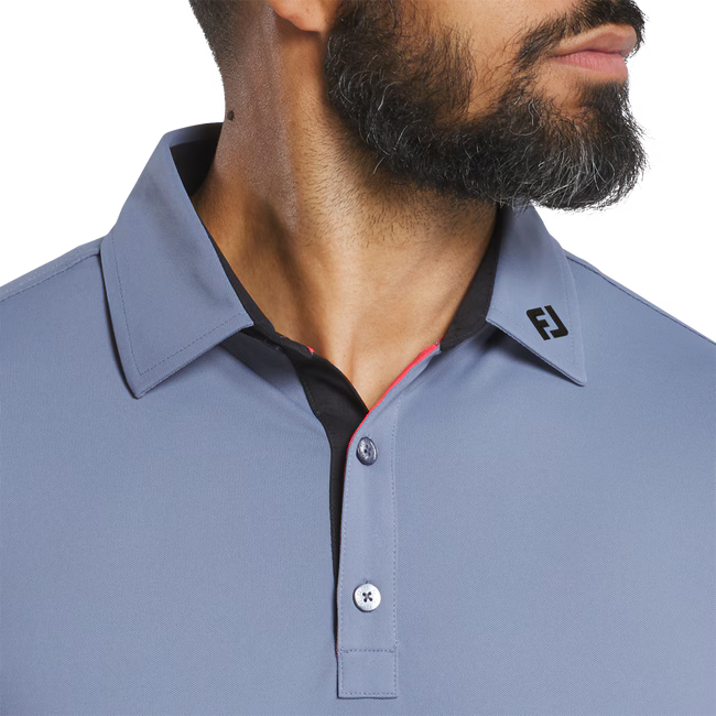 Close-up of a gray polo shirt with a brand logo on the collar against a white background