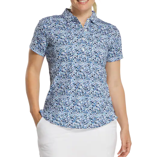 Woman wearing a blue floral short-sleeve shirt and white skirt on a white background