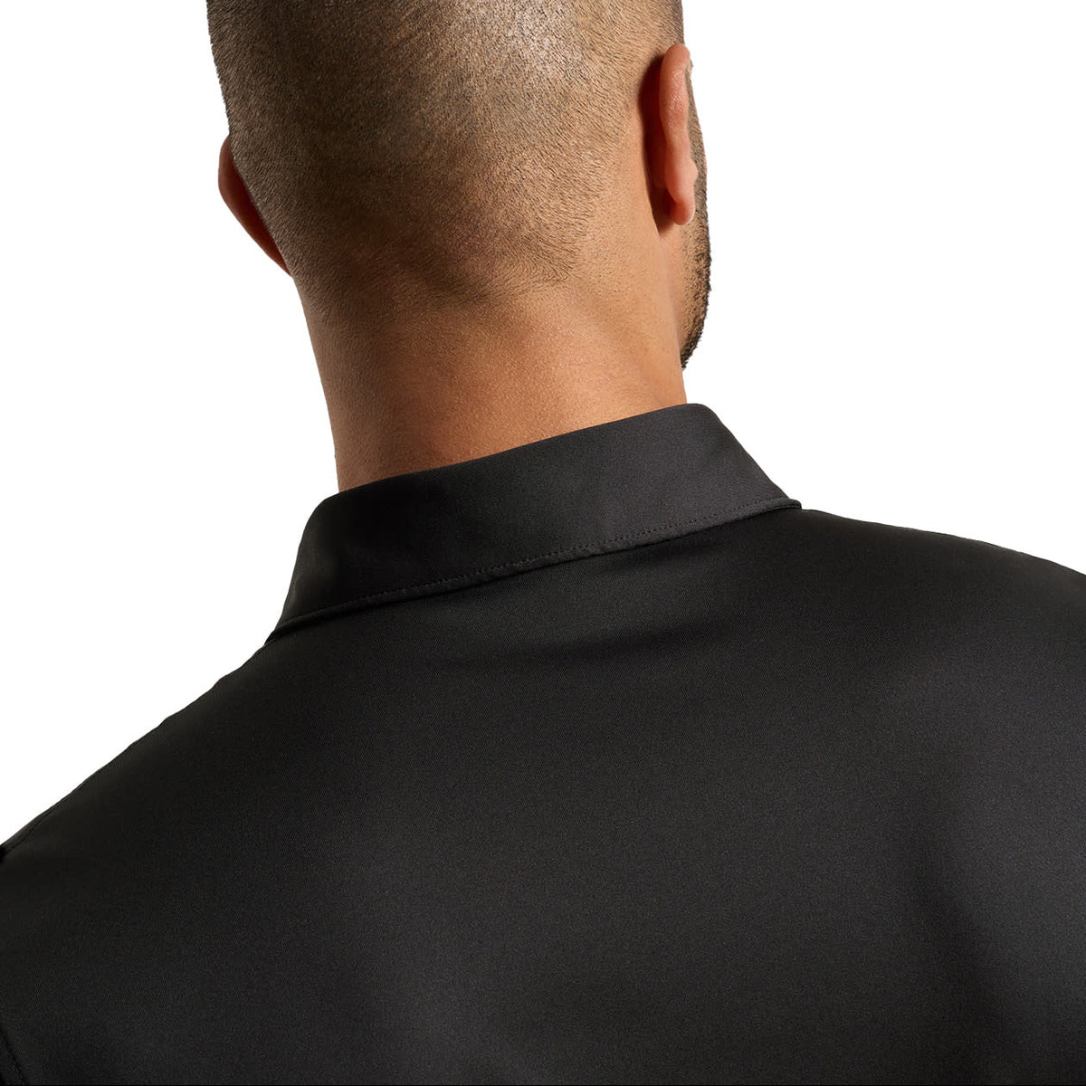 Close-up back view of a man wearing a black collared shirt against a plain white background.