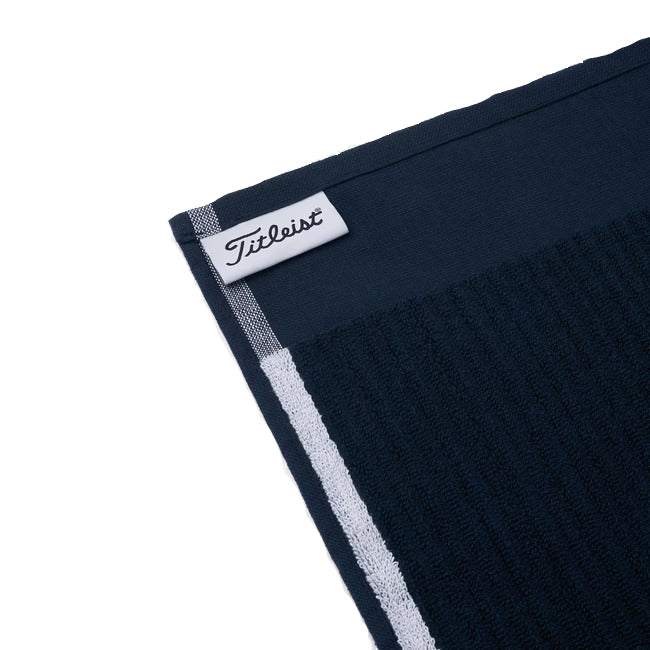 Navy blue towel with a white label featuring the Titleist logo on a white background
